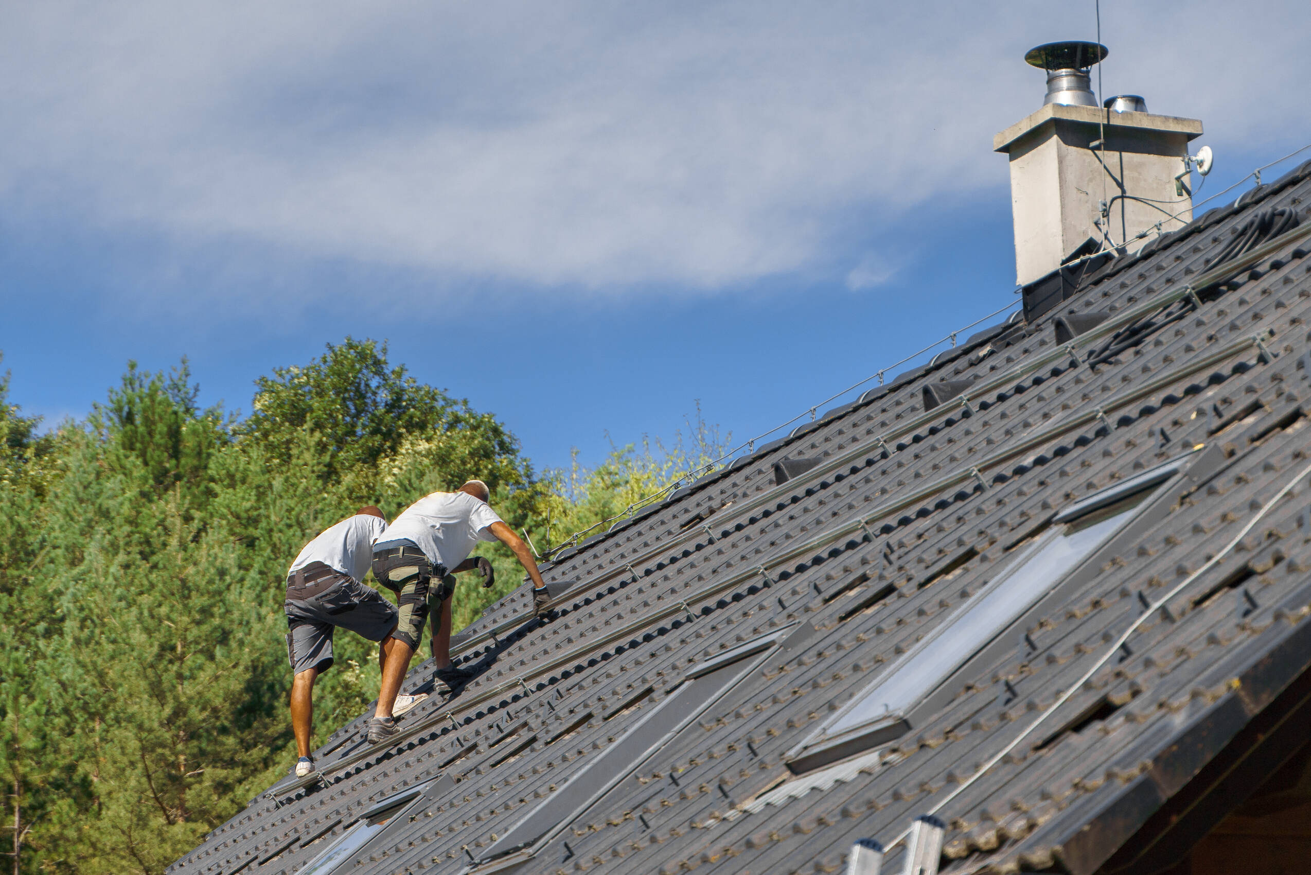 Construction workers on tiled rooftop on sunny day 2026 03 10 04 47 57 utc