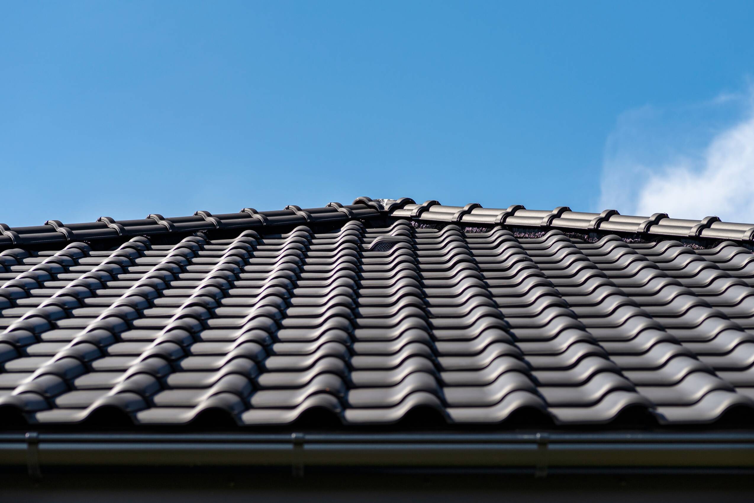Black roof tiles against a blue sky 2026 03 19 23 57 22 utc